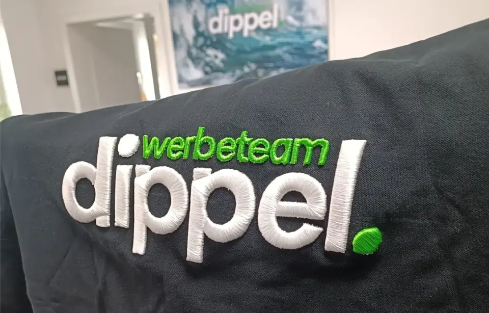 Besticktes Textil mit Firmenlogo und Schriftzug