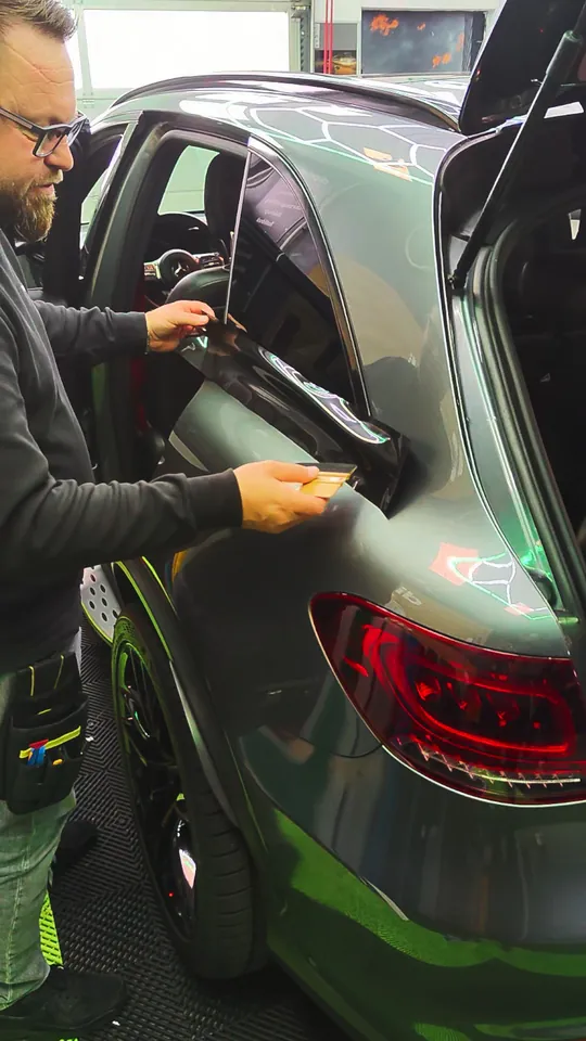 Chrome delete on a Mercedes-AMG GLC – black film being applied to the rear window trim