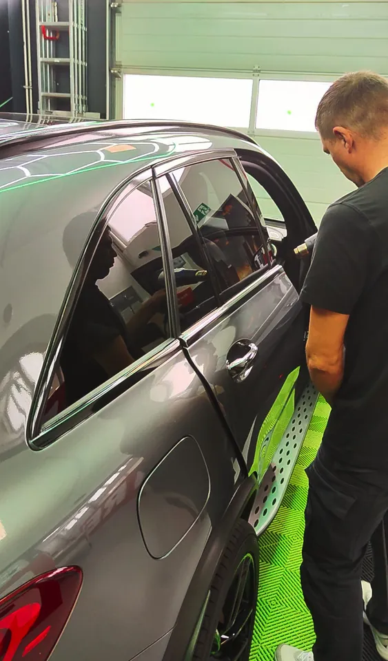 Film being heated with a heat gun – chrome delete of the window trims on a Mercedes-AMG GLC
