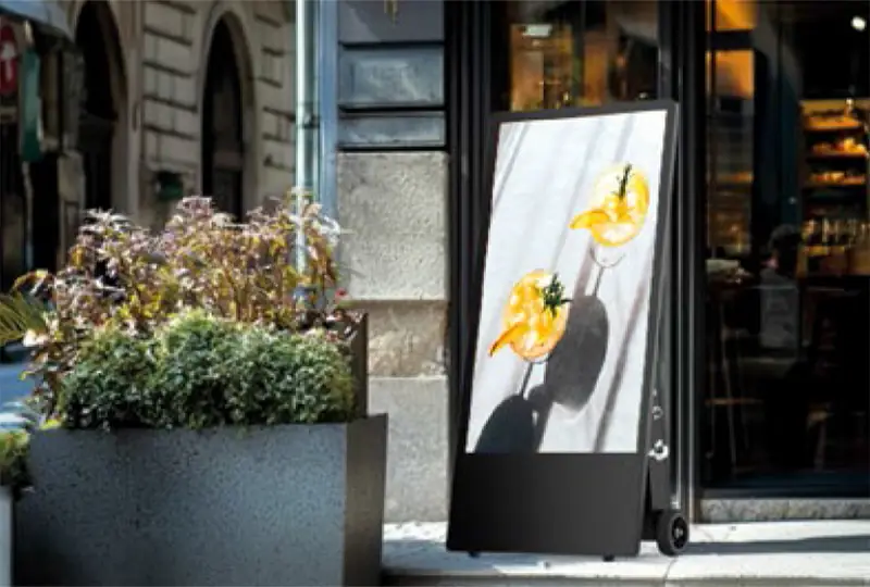 Digital Kundenstopper vor Geschäft zeigt Getränke-Werbung