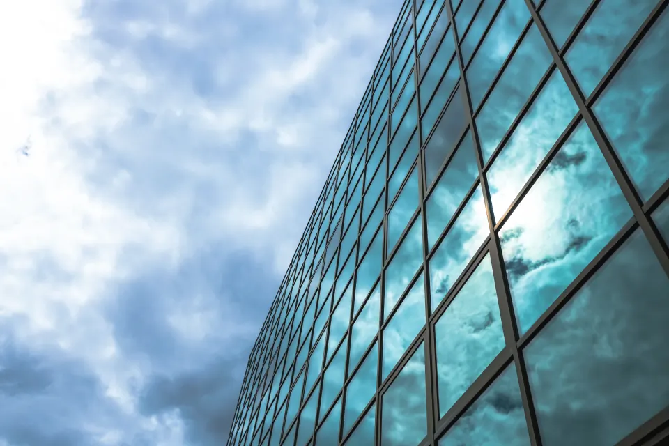 Glasfassade mit Spiegelfolie und Wolkenspiegelung, Außenansicht eines Gebäudes